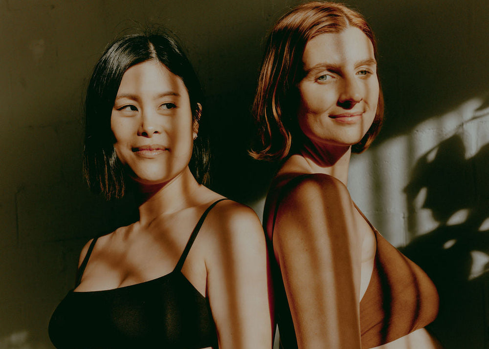 Two women standing side by side with a warm, natural light effect.